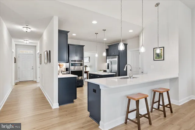 a kitchen with kitchen island a sink stove and refrigerator