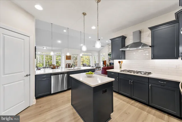 a kitchen with stainless steel appliances granite countertop a sink a stove and a refrigerator