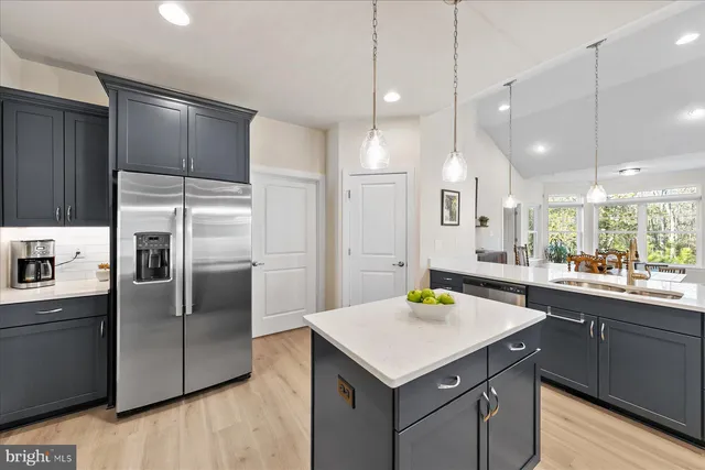 a kitchen with a sink a kitchen island wooden cabinetry and stainless steel appliances