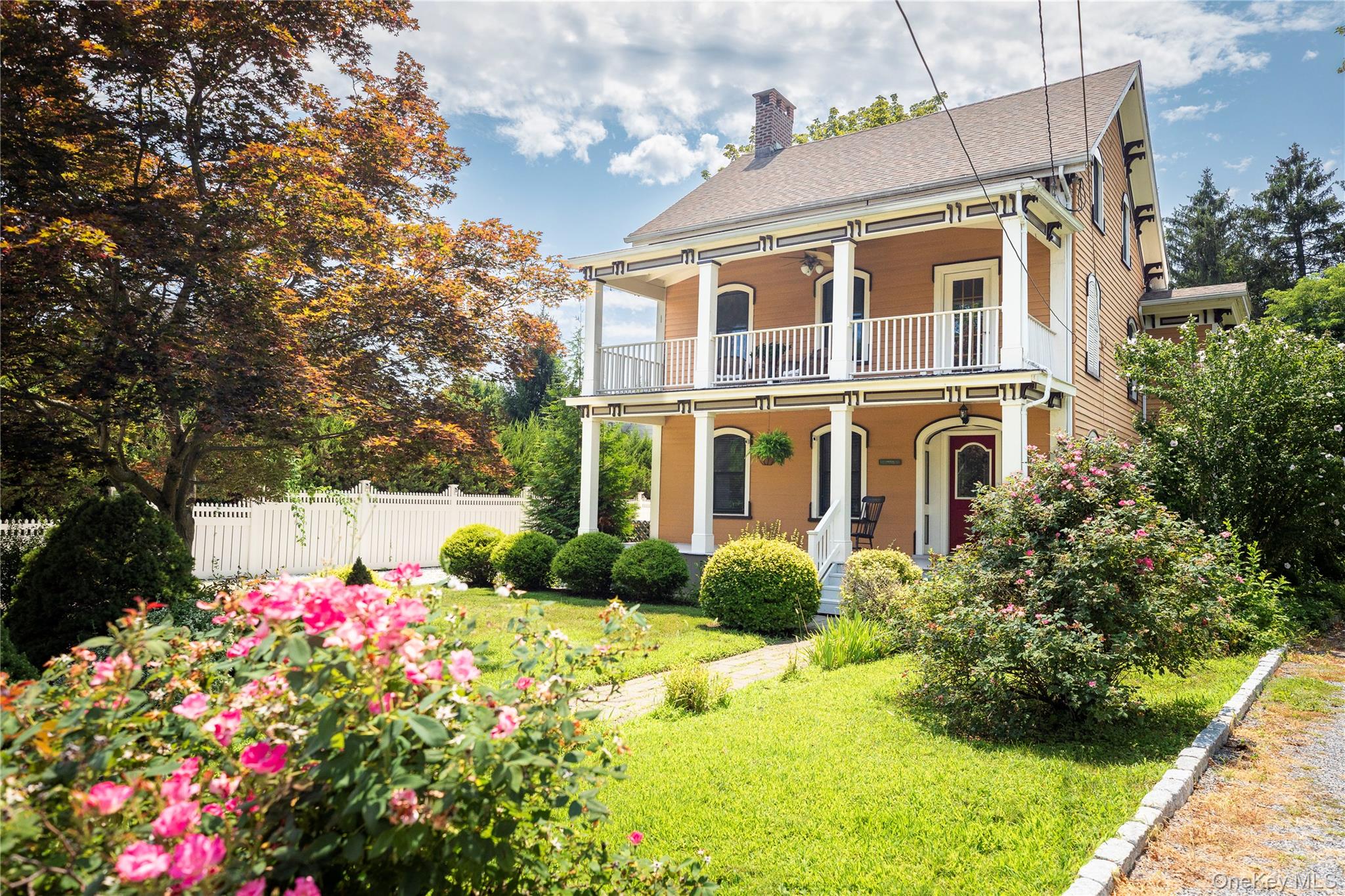a front view of house and yard with beautiful flowers and green space