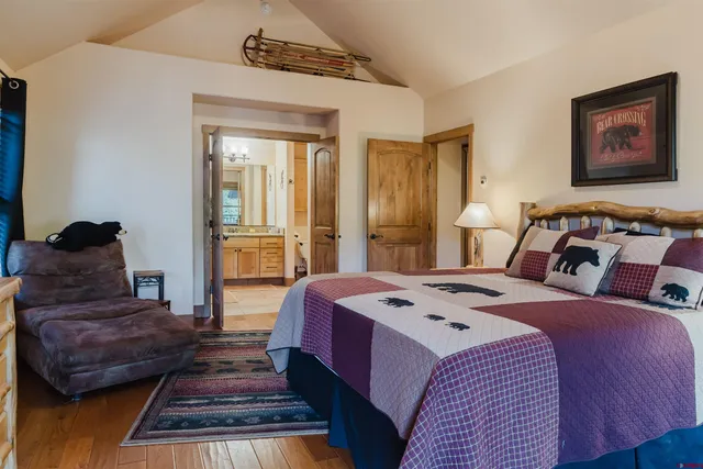 a large bedroom with a bed and wooden floor