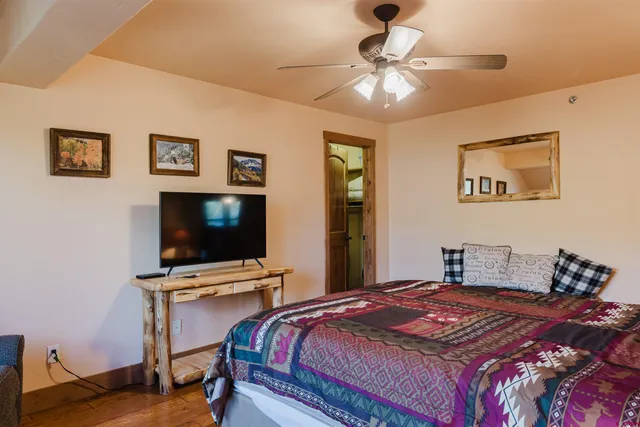 a bedroom with a bed and a flat screen tv
