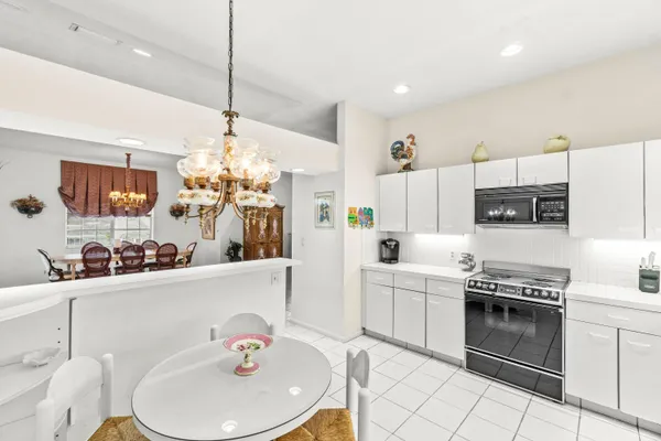 a kitchen with stainless steel appliances kitchen island granite countertop a sink a stove a dining table and chairs