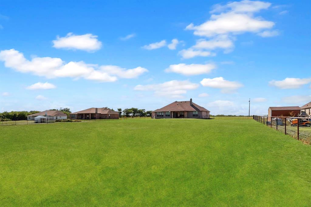 634 Gant Road Sherman, TX 75090 - Photo 31 of 40 Expansive green lawn with a black metal fence enclosing the property