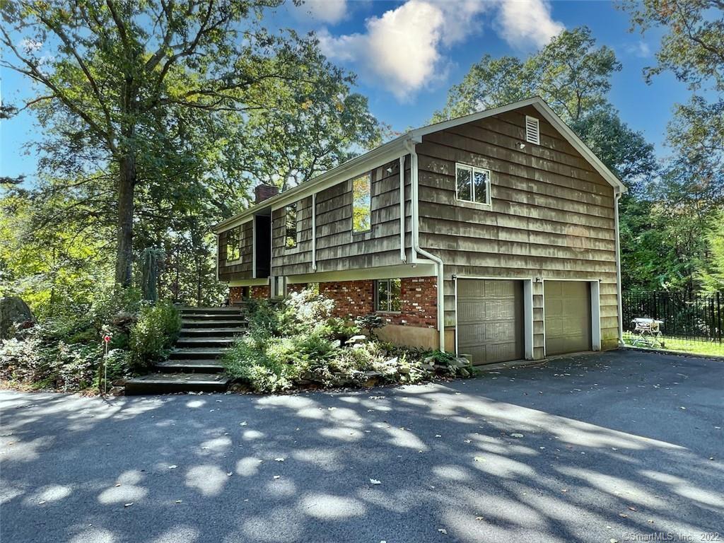 1093 Rock Rimmon Road Stamford, CT 06903 - Photo 1 of 1 a front view of a house with a garden