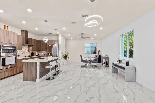 a kitchen with stainless steel appliances kitchen island granite countertop a sink and cabinets