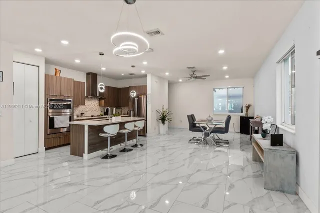 a kitchen with stainless steel appliances kitchen island granite countertop a sink and cabinets