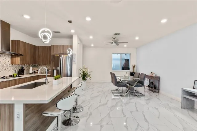 a large white kitchen with a large window and stainless steel appliances