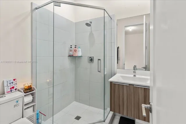a bathroom with a shower sink and mirror