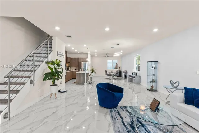 a living room with furniture a potted plant and a table