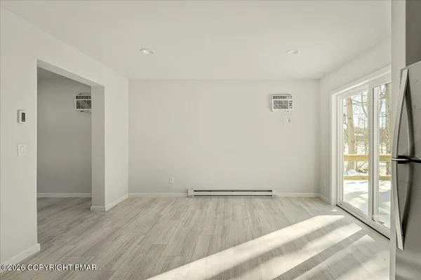 a view of a room with wooden floor and a bathroom