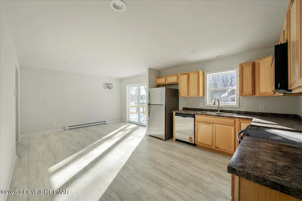 a kitchen with granite countertop a sink cabinets and stainless steel appliances