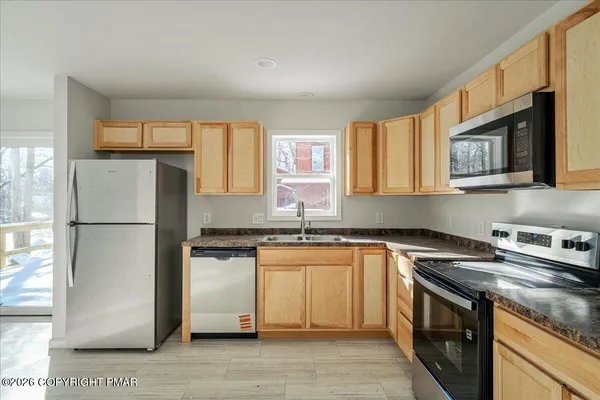a kitchen with stainless steel appliances granite countertop a stove a sink and a refrigerator