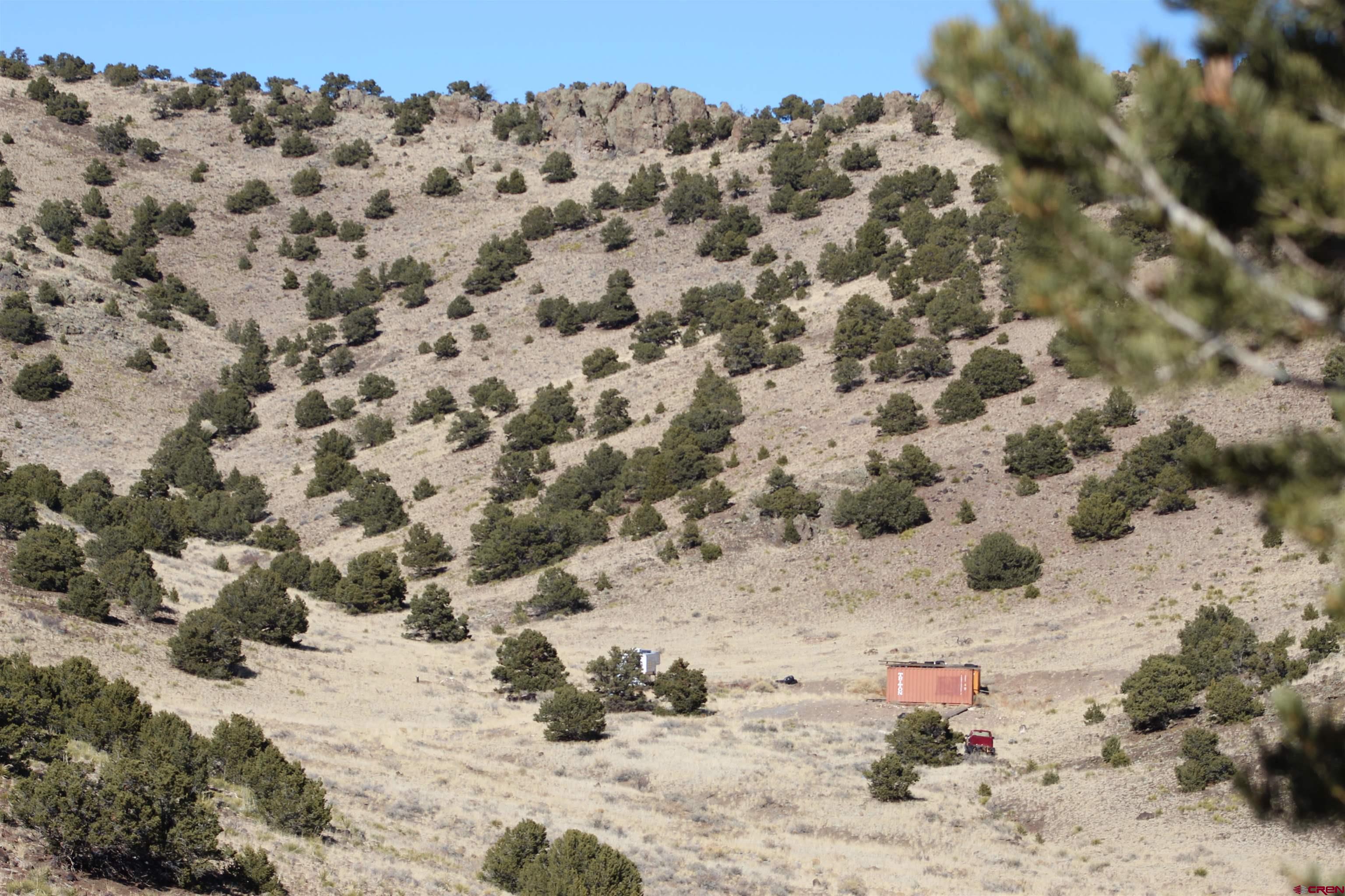 7 Ghost Mine Ranch Del Norte, CO 81132 - Photo 14 of 35 a view of a dry yard covered with snow in the background