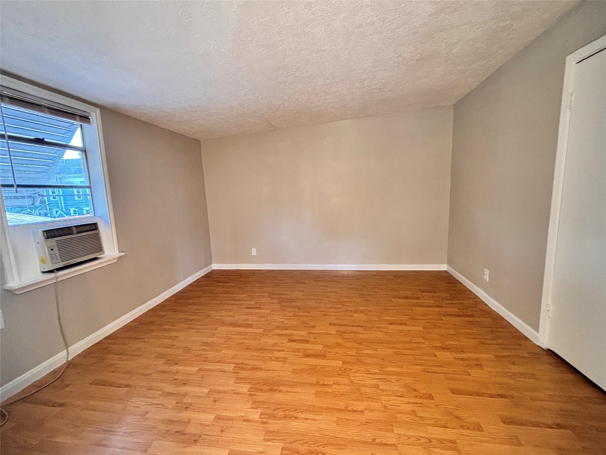 216 Redan Street, Unit 4 Houston, TX 77009 - Photo 2 of 8 a view of an empty room with wooden floor and a window