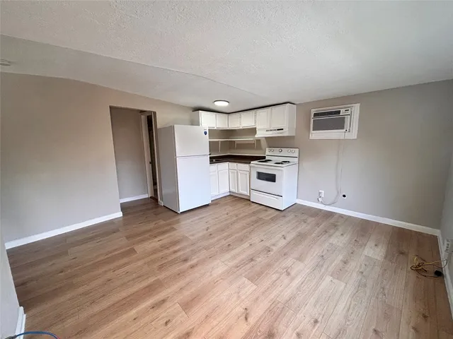 a kitchen with a refrigerator and a stove top oven