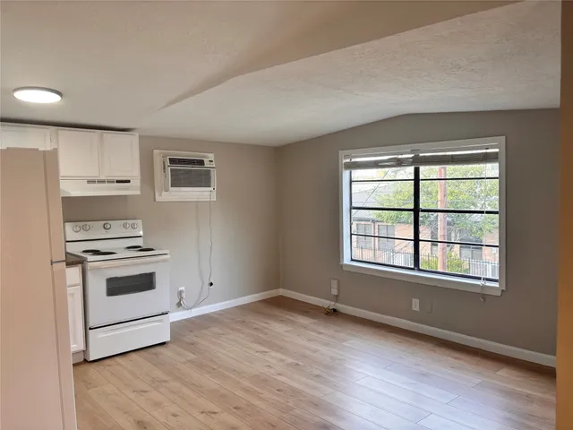 a kitchen with granite countertop a stove a sink and a refrigerator
