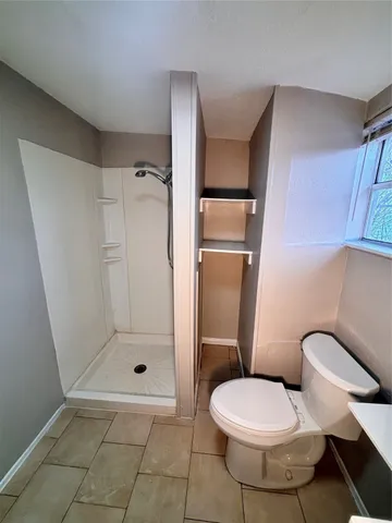 a bathroom with a toilet and a shower
