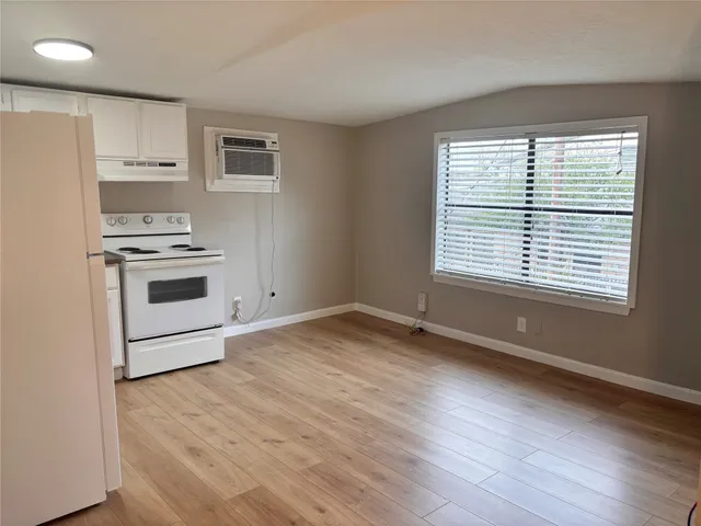 a view of kitchen with a stove wooden floor and window