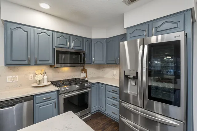 a view of a hallway with wooden floor and a bathroom