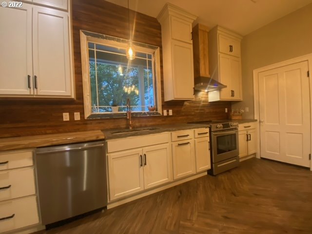 173 West Bryan Street Union, OR 97883 - Photo 8 of 32 a kitchen with granite countertop white cabinets and white appliances with wooden floor