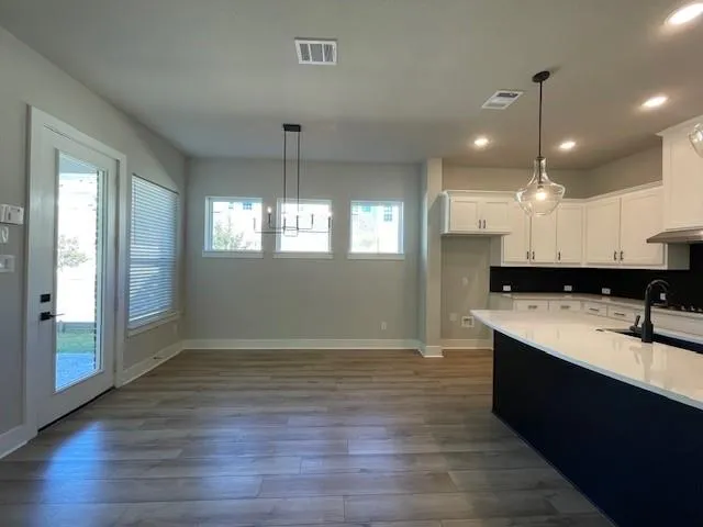 a view of kitchen with sink microwave and cabinets