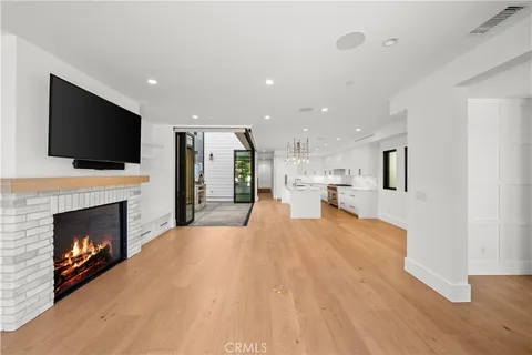 a open kitchen view with fireplace a flat screen tv and a fireplace