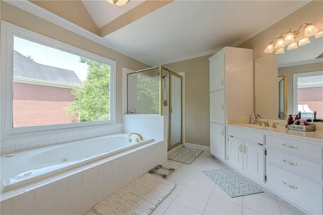 a spacious bathroom with a tub sink and mirror
