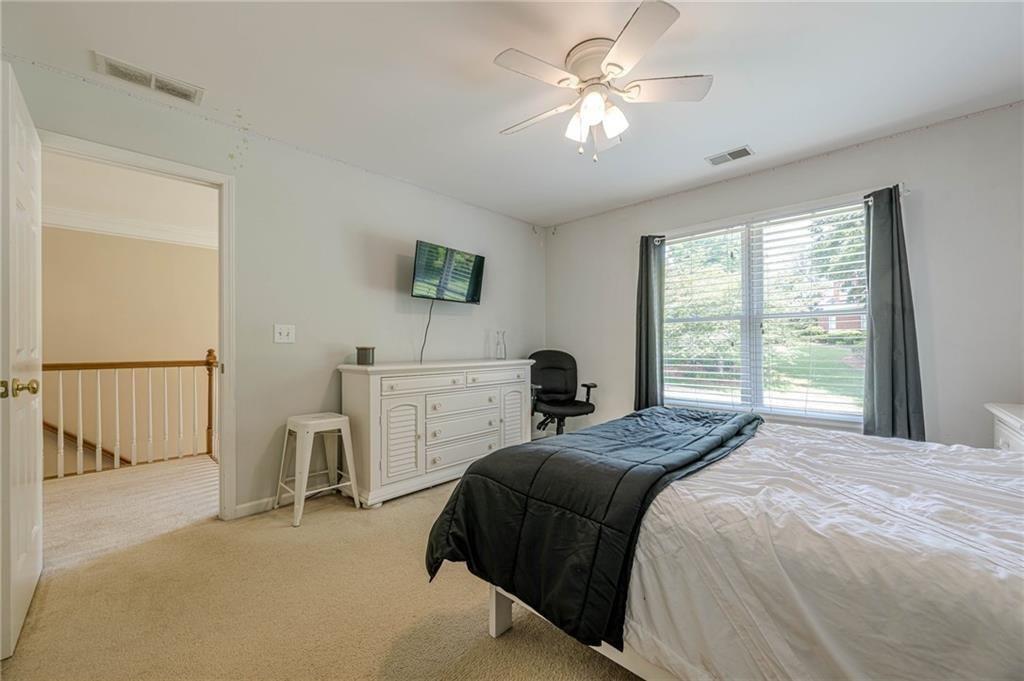 1765 Pinetree Pass Lane Southwest Lilburn, GA 30047 - Photo 26 of 44 a bedroom with a bed a chandelier and a window