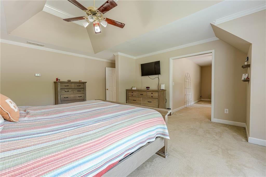 1765 Pinetree Pass Lane Southwest Lilburn, GA 30047 - Photo 27 of 44 a bedroom with a bed and a chandelier