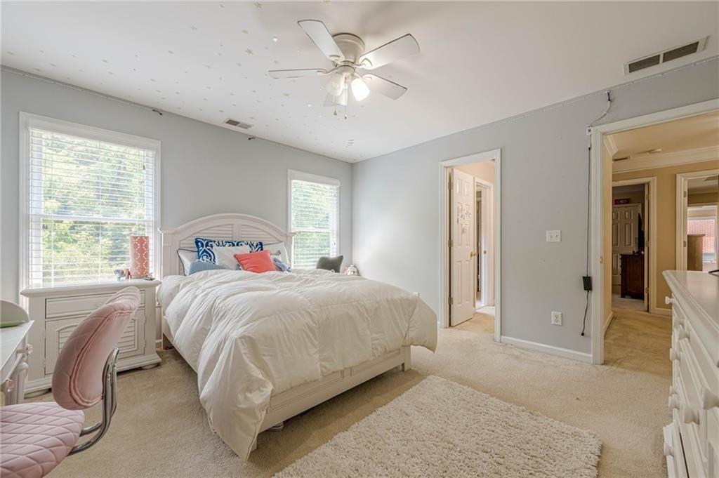 1765 Pinetree Pass Lane Southwest Lilburn, GA 30047 - Photo 28 of 44 a bedroom with a large bed and a chandelier