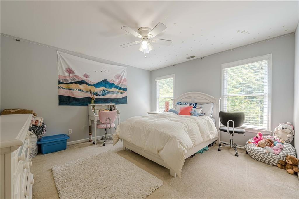 1765 Pinetree Pass Lane Southwest Lilburn, GA 30047 - Photo 29 of 44 a bedroom with a bed and a chandelier