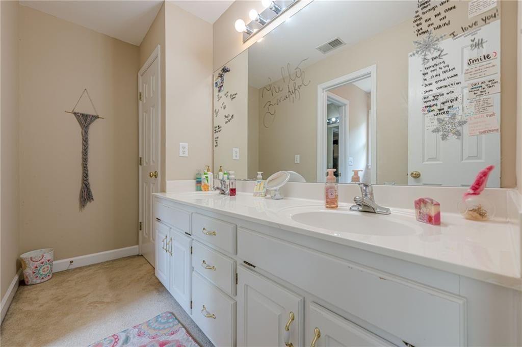 1765 Pinetree Pass Lane Southwest Lilburn, GA 30047 - Photo 30 of 44 a bathroom with a double vanity sink and a mirror