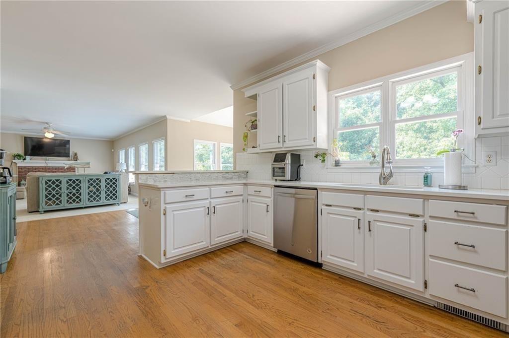1765 Pinetree Pass Lane Southwest Lilburn, GA 30047 - Photo 9 of 44 a kitchen with wooden floors and white appliances