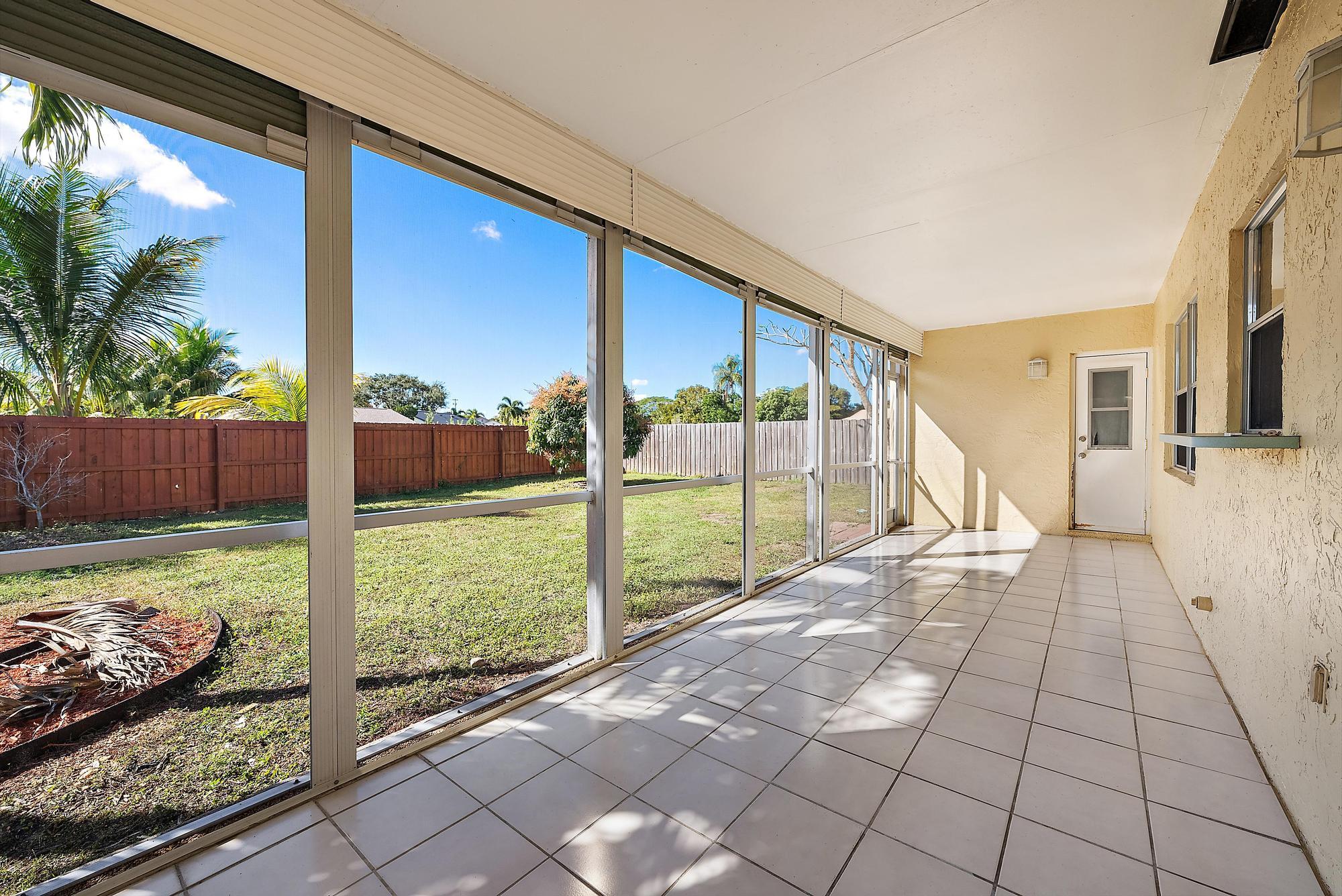 1199 Jackpine Street Wellington, FL 33414 - Photo 17 of 20 a view of backyard with large trees and wooden fence