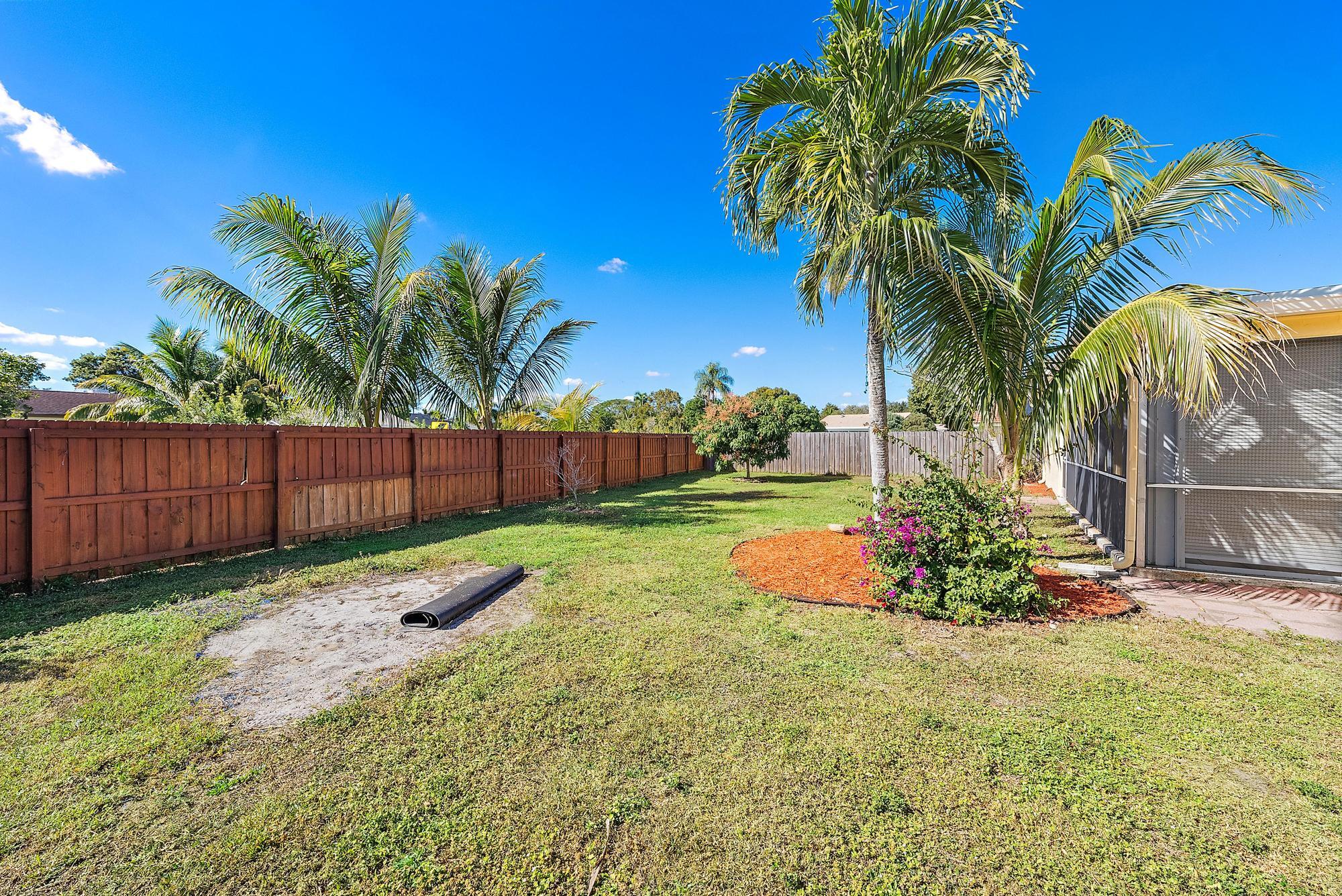 1199 Jackpine Street Wellington, FL 33414 - Photo 19 of 20 a garden with flowers and wooden fence