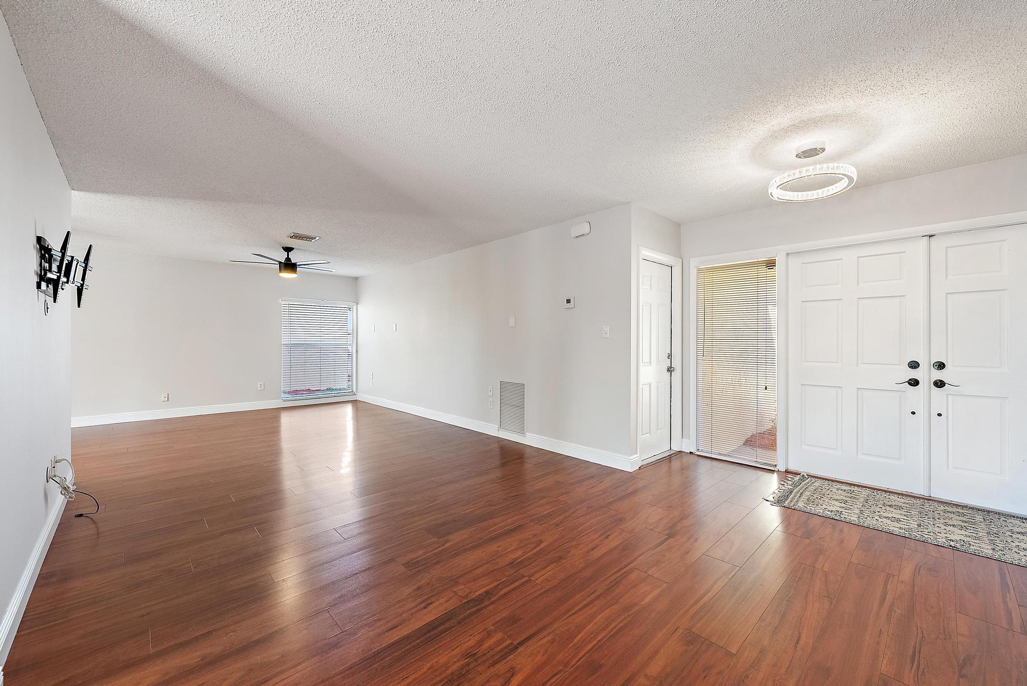 1199 Jackpine Street Wellington, FL 33414 - Photo 4 of 20 an empty room with wooden floor and windows