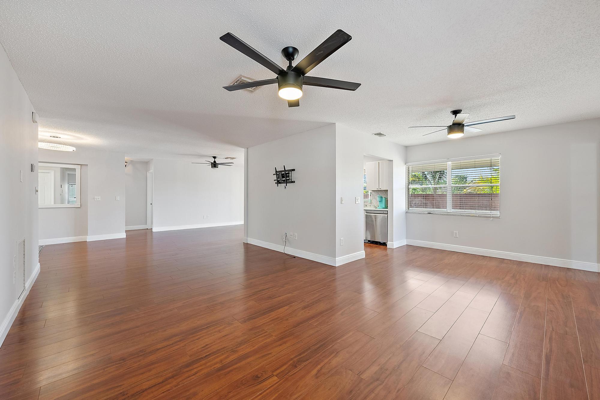 1199 Jackpine Street Wellington, FL 33414 - Photo 5 of 20 a view of an empty room with wooden floor and a window