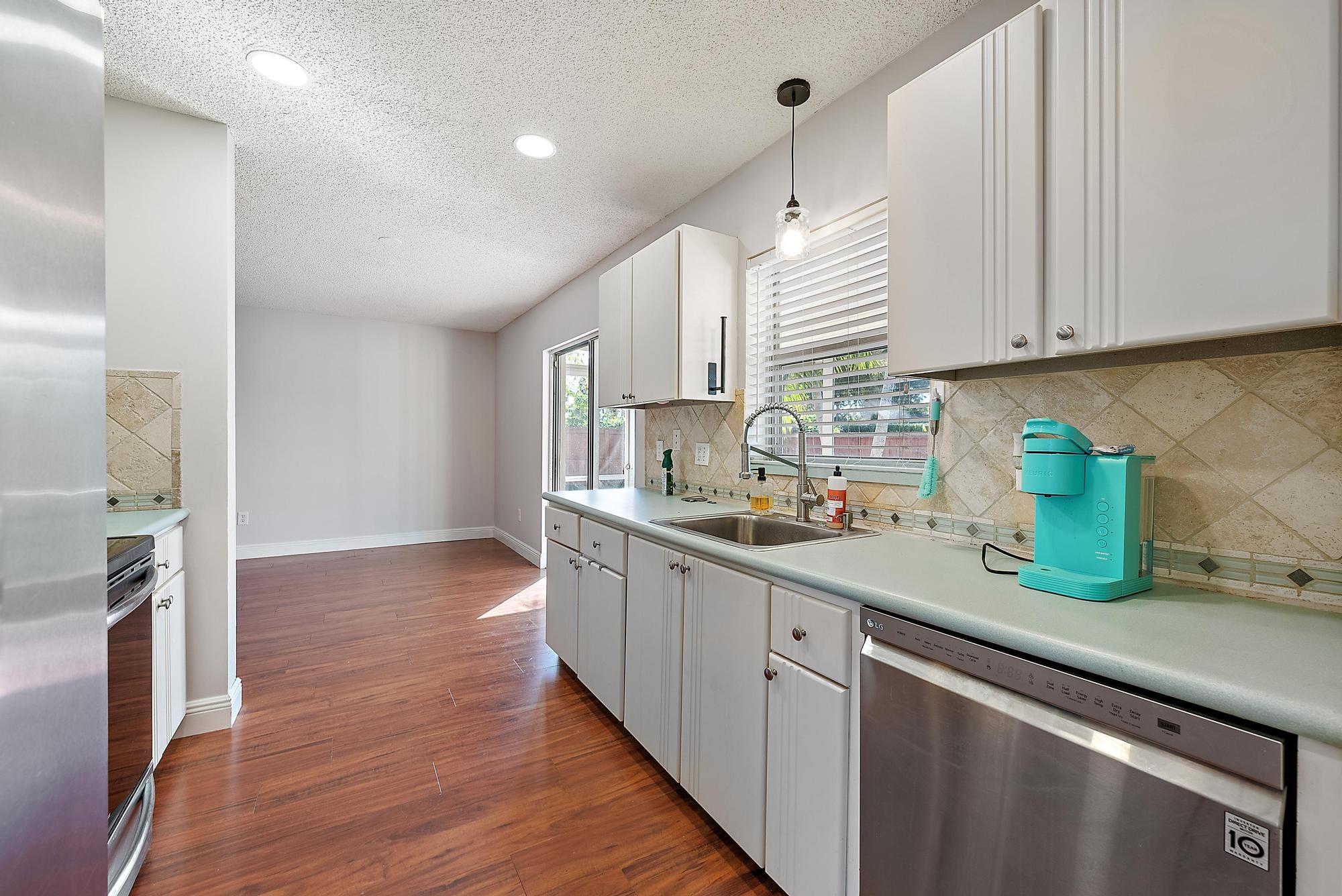 1199 Jackpine Street Wellington, FL 33414 - Photo 8 of 20 a kitchen with sink cabinets and wooden floor