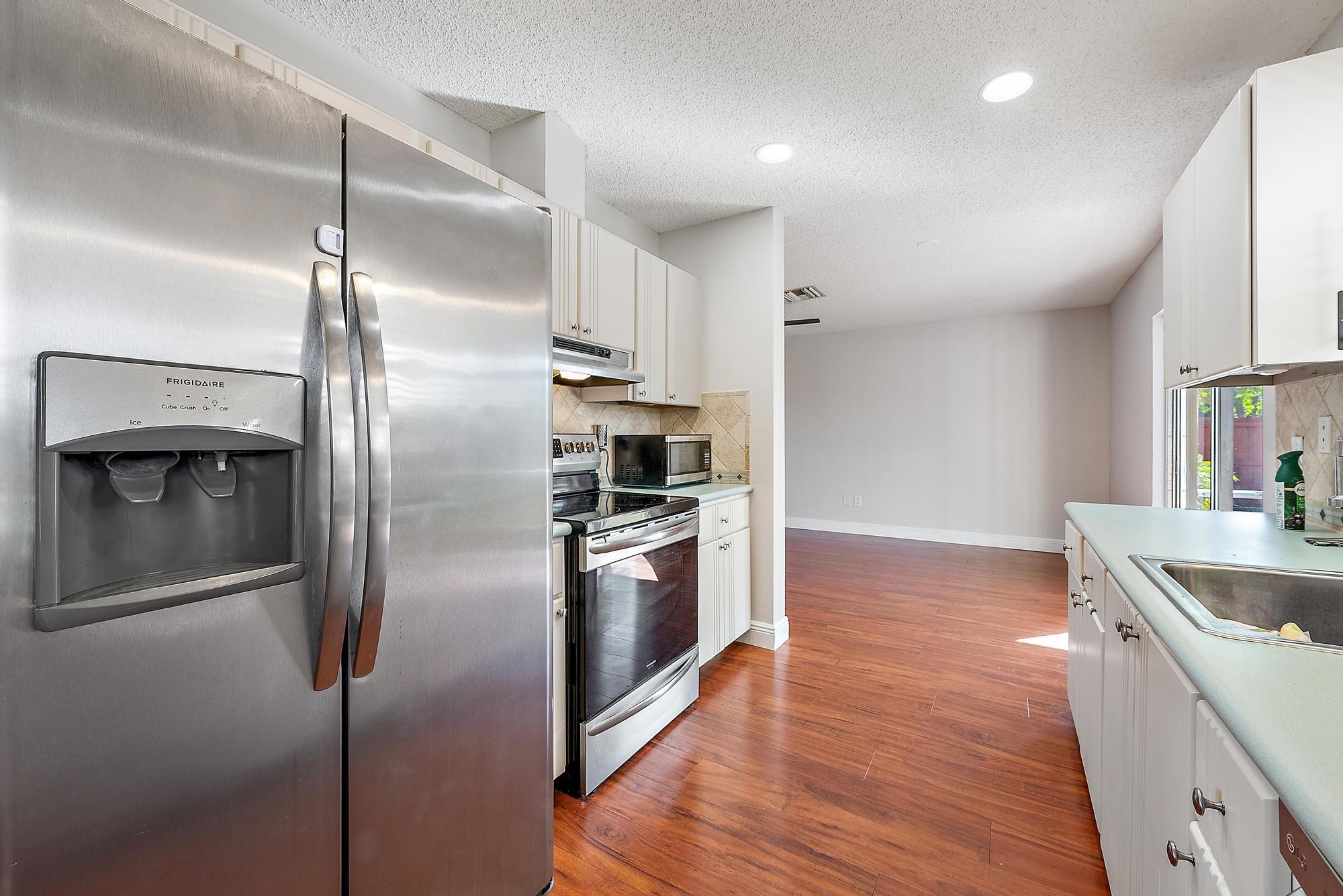 1199 Jackpine Street Wellington, FL 33414 - Photo 9 of 20 a kitchen with kitchen island a counter top space and stainless steel appliances