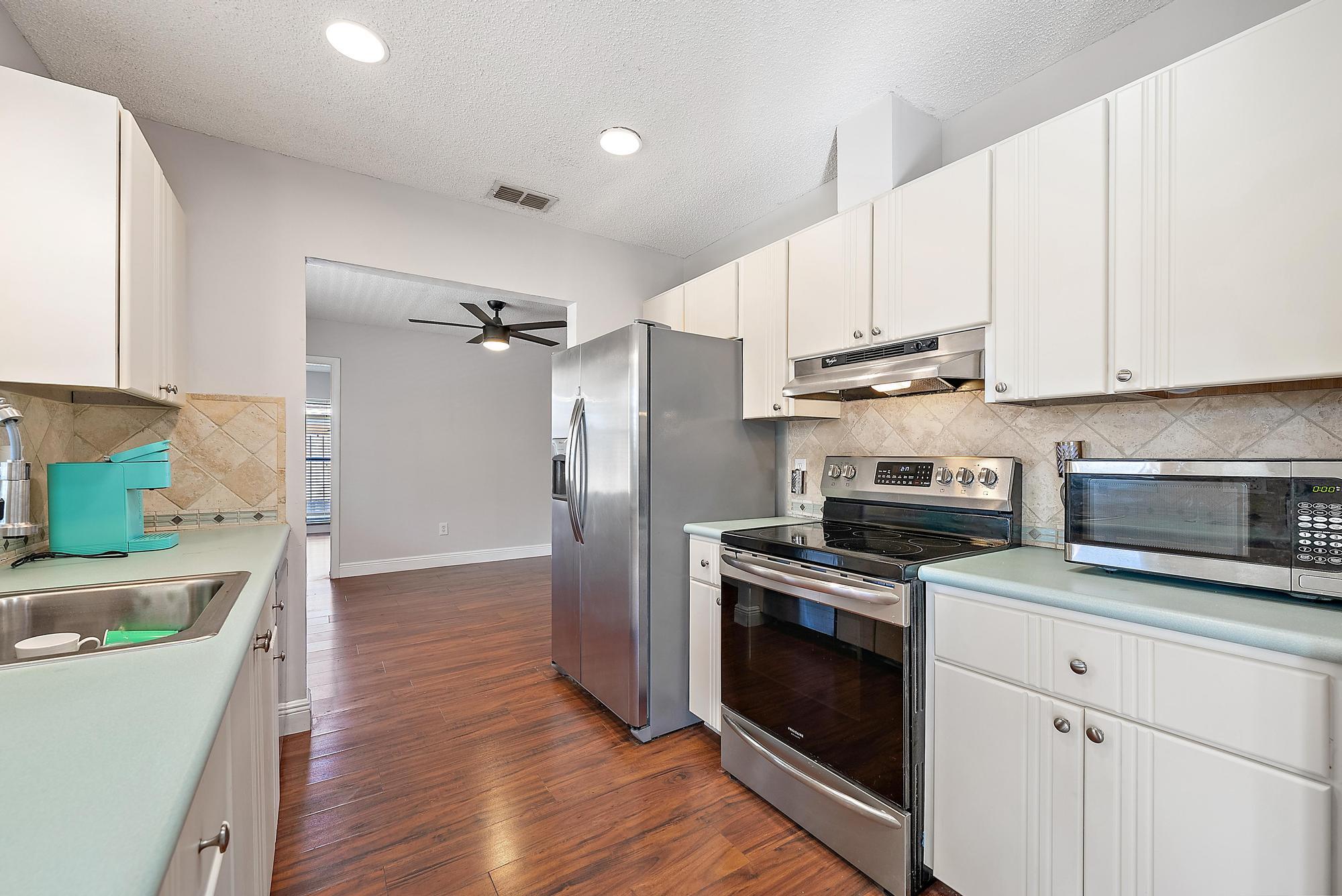 1199 Jackpine Street Wellington, FL 33414 - Photo 10 of 20 a kitchen with cabinets and steel stainless steel appliances