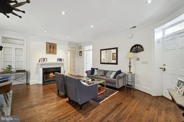a living room with furniture a fireplace and wooden floor