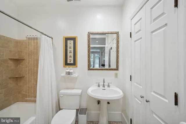 a bathroom with a sink toilet a mirror and shower