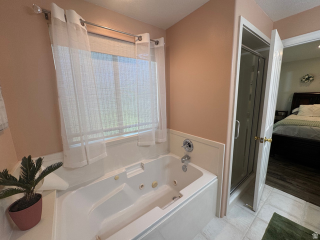 1976 River Bottom Road Springville, UT 84663 - Photo 23 of 45 Bathroom featuring a built-in jetted tub with white surround, an individual shower stall with glass enclosure, and light-colored tile flooring