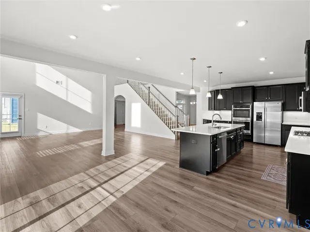 a large white kitchen with a large counter top and stainless steel appliances