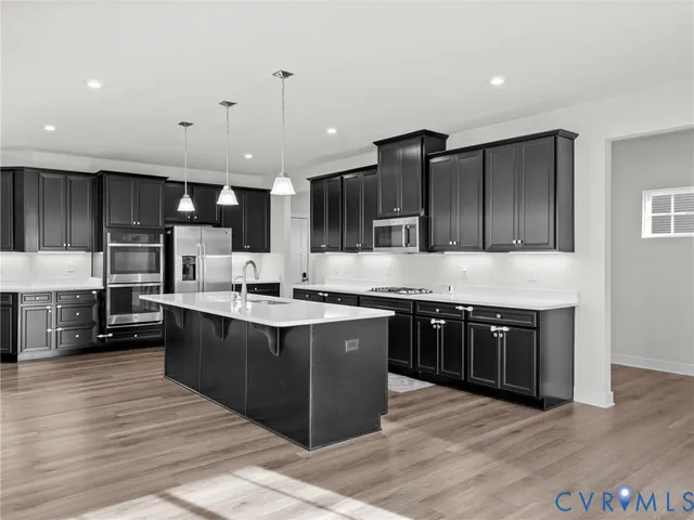a large kitchen with stainless steel appliances kitchen island granite countertop a large counter top and stove top oven
