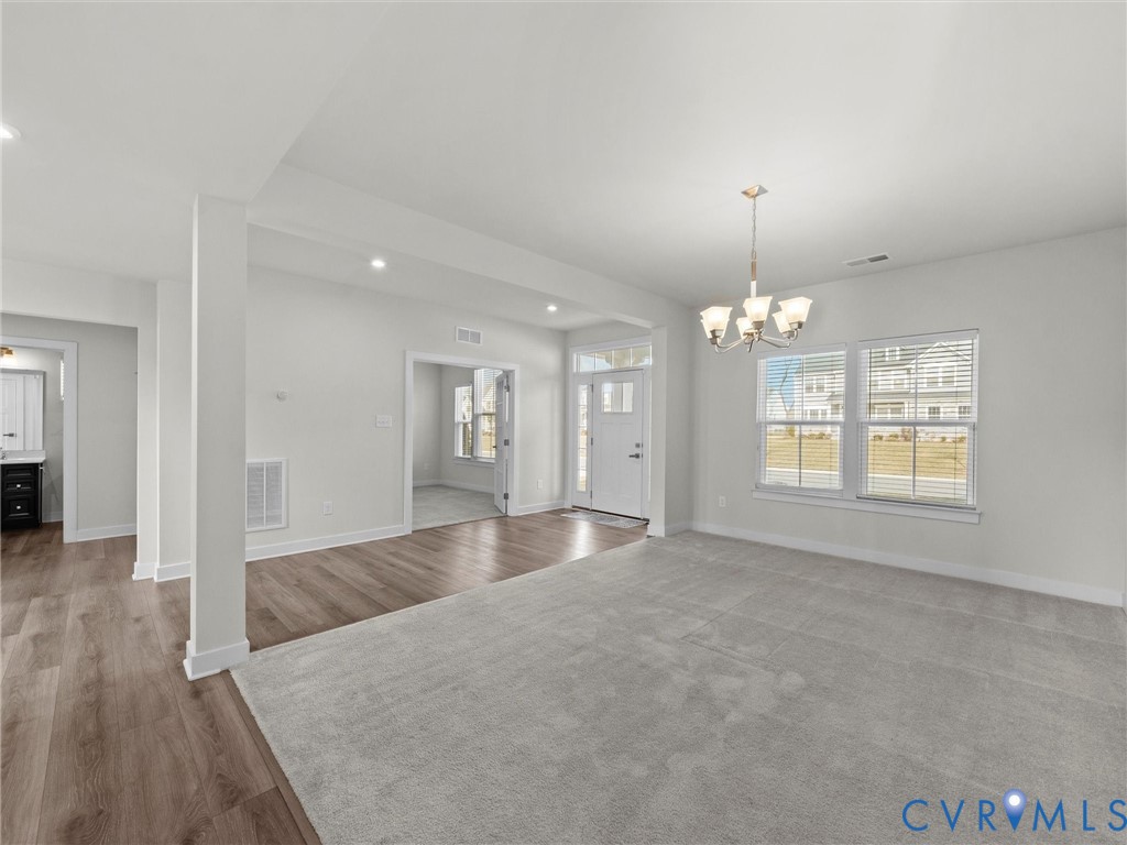 12029 Almer Lane Chester, VA 23836 - Photo 8 of 50 an empty room with wooden floor chandelier and windows