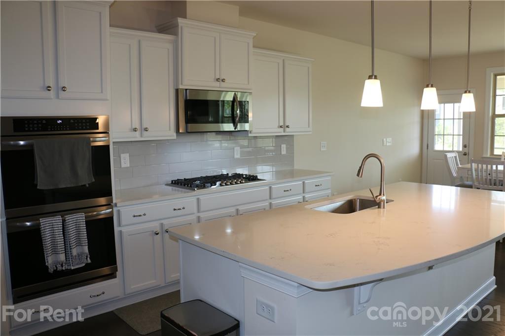 17540 Shearer Road Davidson, NC 28036 - Photo 3 of 27 a kitchen with stainless steel appliances a sink a stove and a microwave