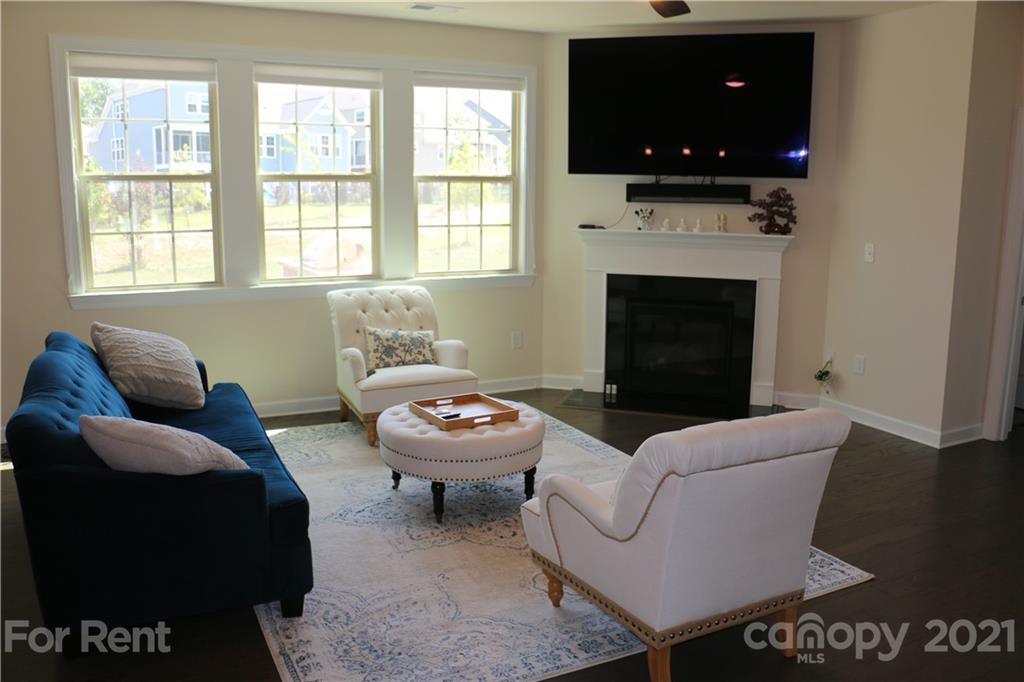 17540 Shearer Road Davidson, NC 28036 - Photo 6 of 27 a living room with furniture a flat screen tv and a fireplace