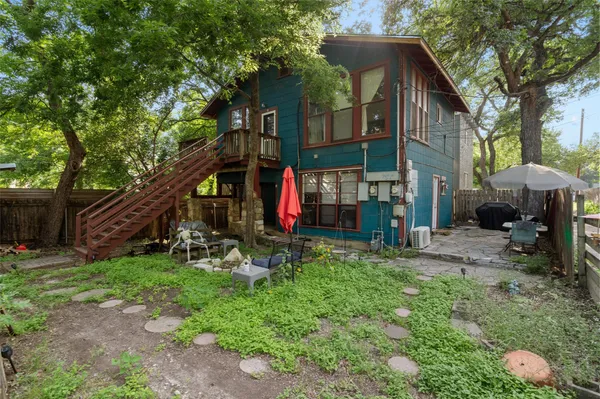 a view of a chair and table in backyard of the house